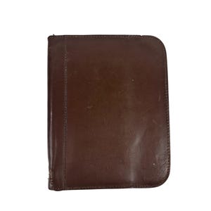 May include: A brown leather portfolio with a stitched edge.
