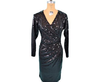 May include: A black sequined dress with long sleeves and a V-neckline. The dress has a wrap style and is fitted.