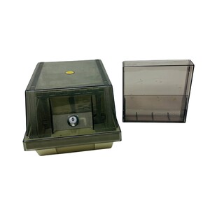 Peut inclure: Une boîte de rangement en plastique transparent avec un couvercle et un plateau en plastique transparent séparé. La boîte a une petite serrure à l'avant.