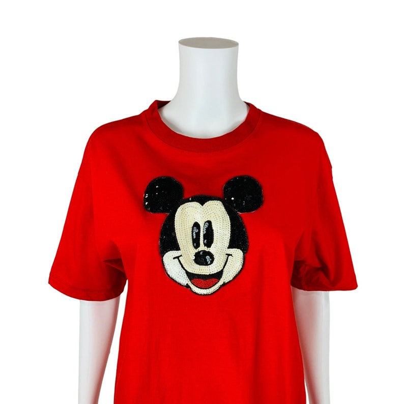 May include: Red short-sleeved t-shirt with a sequined Mickey Mouse appliqu&eacute;.