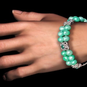 Aqua-green pearl bracelet with silver spacer beads and rhinestones.