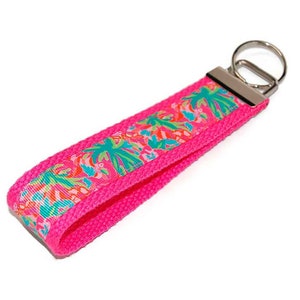 May include: A pink key chain with a floral pattern and a silver key ring.