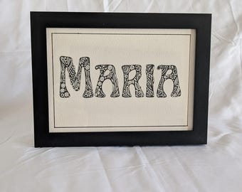 Cuadro con nombre. Letras con estilo de dibujo original y divertido. Tamaño A5. Regalo hecho a mano. Rotuladores de punta fina negros sobre papel blanco.