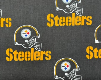 May include: Black fabric with a repeating pattern of a yellow "Steelers" logo and a black and white football helmet with a yellow star.
