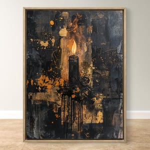 Könnte beinhalten: Abstrakte gerahmte Kunst mit einer schwarzen Kerze mit brennender Flamme. Der Hintergrund ist eine strukturierte Collage aus schwarzen, goldenen und orangenen Farbtönen mit Tropfen und Spritzern. Das Kunstwerk befindet sich in einem hellen Holzrahmen.