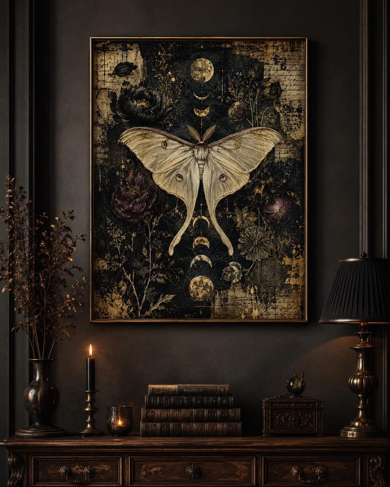 Puede incluir: Una impresi&oacute;n de arte mural rectangular que presenta una gran polilla p&aacute;lida centrada sobre un fondo oscuro y texturizado. La composici&oacute;n incluye fases lunares doradas, elementos florales dispersos y texto tenue, todo en un marco fino.