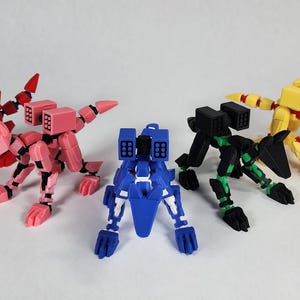Puede incluir: Colección de juguetes de animales robot articulados y coloridos en rojo, rosa, azul, verde y amarillo. Cada robot tiene un diseño único, con estructuras similares a misiles y extremidades segmentadas. Los juguetes están dispuestos sobre una superficie blanca.