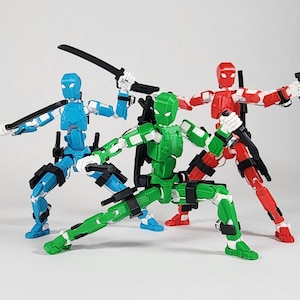 May include: Three articulated action figures in blue, green, and red, each featuring white joint accents and black tactical gear. The figures are posed in dynamic stances, equipped with black plastic swords and handheld weapons held in their hands.