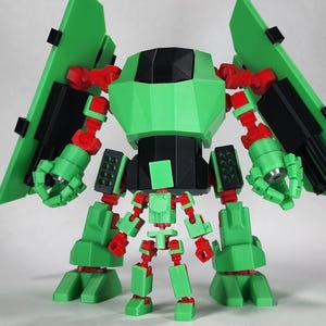 May include: A green and red robot toy with black accents. The robot has large, angular limbs, including two large wing-like structures on its back. The robot's design is geometric and appears to be 3D-printed.