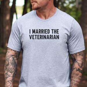 May include: A gray t-shirt with the text "I married the veterinarian" printed in black.