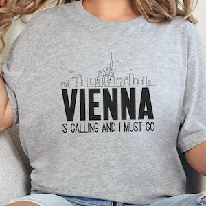 May include: Gray t-shirt with a black graphic of the Vienna skyline and the text "Vienna is calling and I must go."