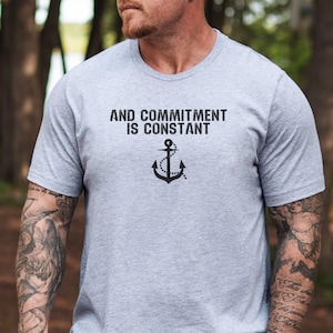 May include: A gray t-shirt with the text "AND COMMITMENT IS CONSTANT" and a black anchor graphic.
