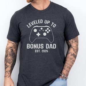Leveled Up To Bonus Dad Est 2026 T-Shirt | Gamer Step Dad Announcement Gift | Future Stepfather Gaming Tee | New Dad Fathers Day Present