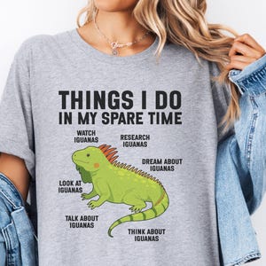 May include: A heather gray t-shirt featuring a green iguana illustration and the text: THINGS I DO IN MY SPARE TIME, WATCH IGUANAS, RESEARCH IGUANAS, DREAM ABOUT IGUANAS, LOOK AT IGUANAS, TALK ABOUT IGUANAS, and THINK ABOUT IGUANAS.