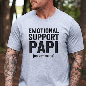 May include: A gray t-shirt with black text that reads "Emotional Support Papi [Do Not Touch]"
