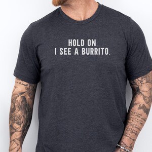 May include: A dark grey t-shirt with the text "Hold on. I see a burrito." printed in white.