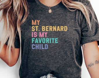 May include: Dark gray t-shirt with the text "MY ST. BERNARD IS MY FAVORITE CHILD" in colorful block letters. The shirt is a crew neck and has short sleeves.
