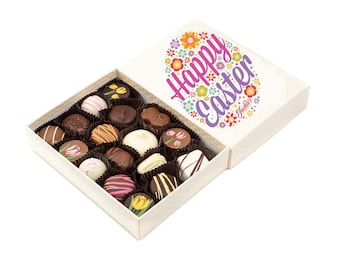May include: A white box with a colorful floral design and the text "Happy Easter" on the lid. The box is open and contains a variety of chocolate truffles.