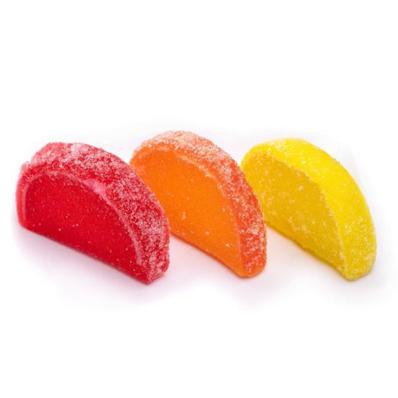 May include: Three gummy candies shaped like orange slices. The candies are red, orange, and yellow.