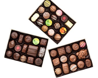 May include: Three boxes of assorted chocolates. Each box contains a variety of dark, milk, and white chocolates with different fillings and designs.