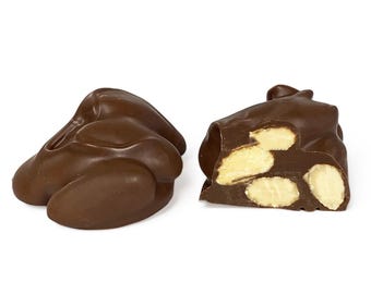 May include: Two chocolate-covered almond clusters, one whole and one cut in half to show the almonds inside.