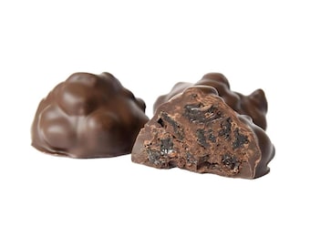May include: Three chocolate-covered candies, one broken open to reveal a dark, chewy filling. The candies are a dark brown color and have a smooth, glossy finish.