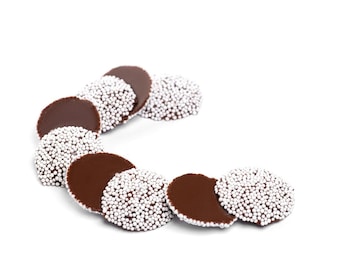May include: A close-up of a row of chocolate candies with white sprinkles. The candies are arranged in a semi-circle shape on a white background.