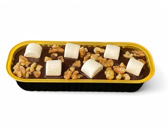 May include: A rectangular dessert in a gold-rimmed black container. The dessert has a dark chocolate base, topped with walnuts and large white marshmallows. The container is on a white background.