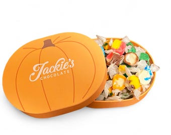 May include: An orange pumpkin-shaped box with the text "Jackie's Chocolate" in a script font. The box is open, revealing a variety of colorful wrapped candies. The candies are in various shapes and colors.