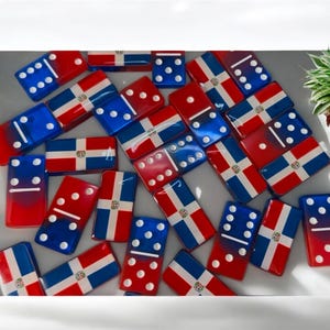 May include: A set of dominoes with the Dominican Republic flag on each tile. The dominoes are red, white, and blue.
