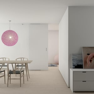 Könnte beinhalten: Ein weißer Essbereich mit einem Holztisch und Stühlen. Eine große rosafarbene Kugel-Leuchte hängt von der Decke. Eine weiße Tür führt in einen anderen Raum mit einem rosafarbenen Gymnastikball.