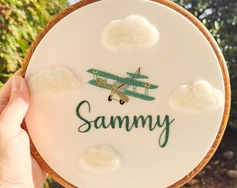 Bastidor de bordado personalizado con nombre de bebé: Avión bordado y nubes de fieltro (8 pulgadas)