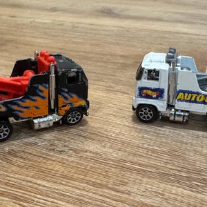 2 Vintage 1981 Hot Wheels Trucks- Auto City White Tow Truck and Black with Flames Rescue Rig- Very Good Condition