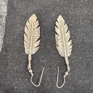 Puede incluir: Un juego de tres tazas de cerámica con un acabado mate moteado. Las tazas son de color crema, gris claro y gris oscuro. Cada taza tiene un diseño simple y minimalista y un asa redondeada.