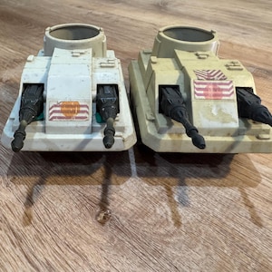 May include: A set of three ceramic mugs with a speckled, matte finish. The mugs are in shades of cream, light gray, and dark gray. Each mug has a simple, minimalist design, perfect for coffee or tea.