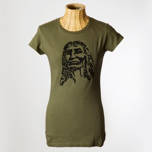 May include: A green t-shirt with a black graphic print of a person's face. The graphic is made up of words, including "The Earth is our", "We believe", and "Care for the Earth".