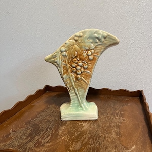 May include: A white ceramic mug with a black handle and the text "But First, Coffee" in a black, handwritten-style font. The mug is on a white surface.