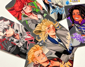 May include: A collection of five rectangular art prints featuring stylized anime-inspired characters with vibrant hair colors, including red, white, blonde, and dark brown. Each print displays a unique character portrait with bold line work and text.