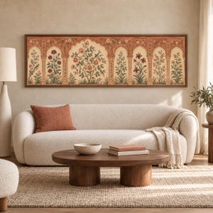 May include: A long rectangular wall art piece featuring a series of arched panels with detailed botanical illustrations of flowers and birds in shades of red, orange, and green, framed in a thin dark wood border above a cream-colored sofa.