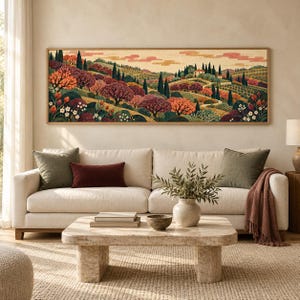 May include: A panoramic landscape painting in a wooden frame featuring rolling hills, cypress trees, and flowering bushes in shades of deep red, orange, green, and cream. The artwork depicts a rural scene with a small house nestled on a hillside.