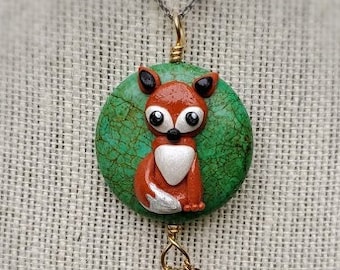 May include: A green and brown fox pendant necklace with a green stone drop and garnet beads.