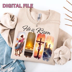 May include: A beige sweatshirt with the text "He is Risen" printed on the front. The text is in black and is surrounded by four images of scenes from the Bible. The images are in a colorful, painterly style.