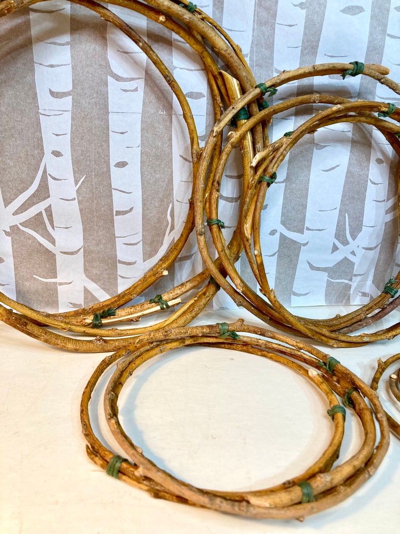 May include: A set of five brown twig wreaths, each tied together with green twine. The wreaths are arranged in a stack, with the largest wreath at the bottom and the smallest wreath at the top.