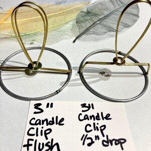 Puede incluir: Dos clips para velas de 7,6 cm, uno con un dise&ntilde;o a ras y el otro con una ca&iacute;da de 1,3 cm. Ambos clips son de metal dorado y tienen una base circular.