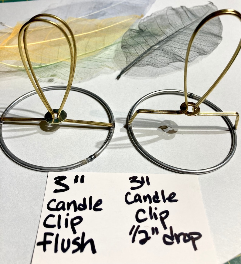 Puede incluir: Dos clips para velas de 7,6 cm, uno con un dise&ntilde;o a ras y el otro con una ca&iacute;da de 1,3 cm. Ambos clips son de metal dorado y tienen una base circular.