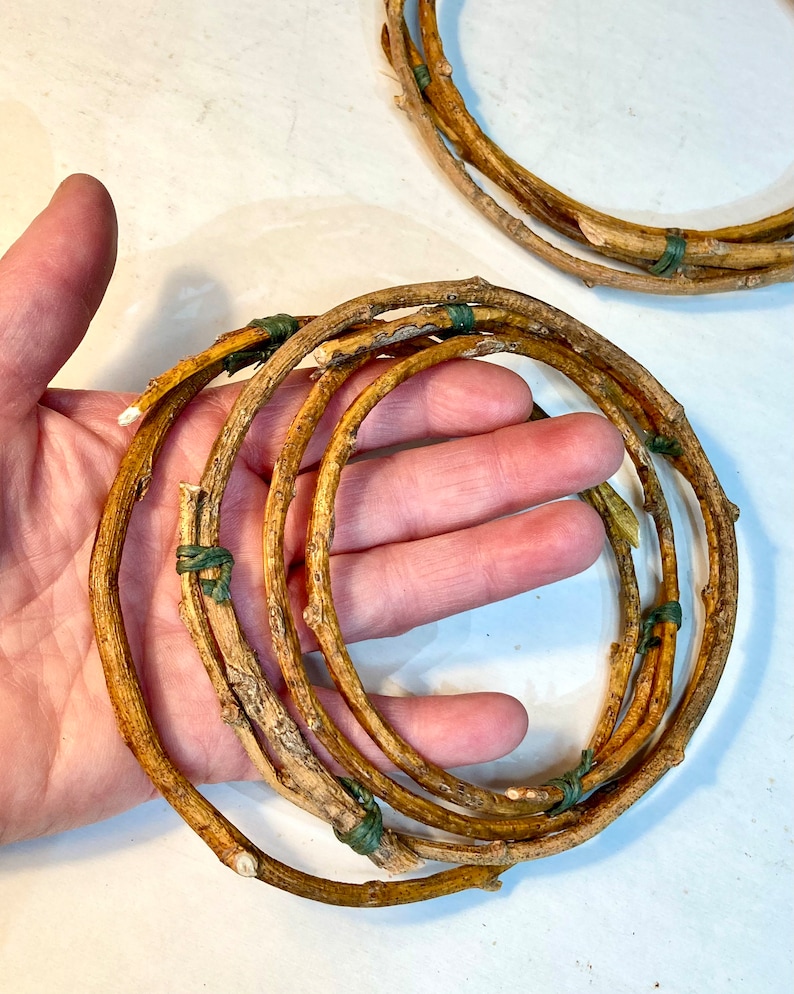 May include: A set of five brown twig wreaths tied together with green string. The wreaths are arranged in a circle and are about 10 inches in diameter.