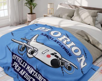 Puede incluir: Una manta azul claro con un diseño de avión de dibujos animados en blanco, negro y rojo. La manta muestra el texto "P3 ORION NAVAL AVIATION" y "OFFICIALLY MAINTAINED BY PER AN DUCT TAE."