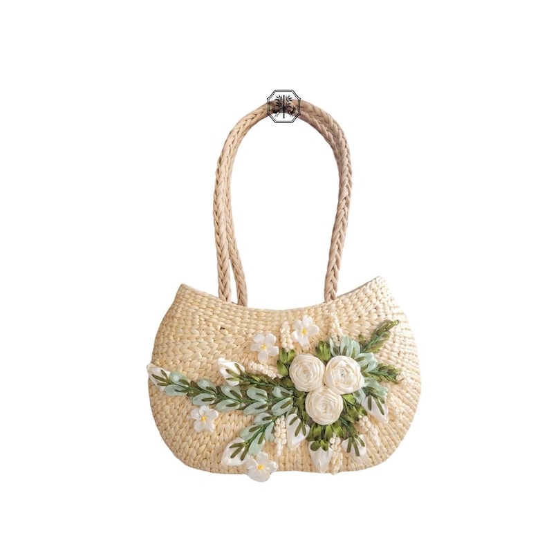 Pu&ograve; includere: Una borsa a mano in paglia intrecciata con manico intrecciato. La borsa &egrave; decorata con ricami floreali bianchi e verdi. La borsa ha una forma arrotondata e un colore naturale, perfetta per trasportare l'essenziale.