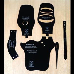 May include: Black leathercraft pattern pieces and tools on a wooden surface. Includes various shapes labeled with text such as "Loop Strap Option" and "Mexican Loop Option". Also includes a needle and a tool labeled "Hammer Thong".