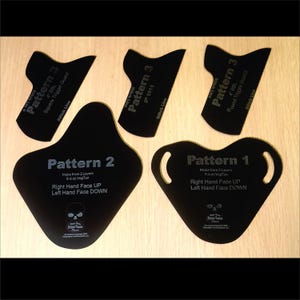 May include: A collection of black leathercraft patterns, including shapes labeled "Pattern 1", "Pattern 2", and "Pattern 3". The patterns are designed for right-handed use and are made from 5-6 oz VegTan leather. The patterns are displayed on a light wooden surface.